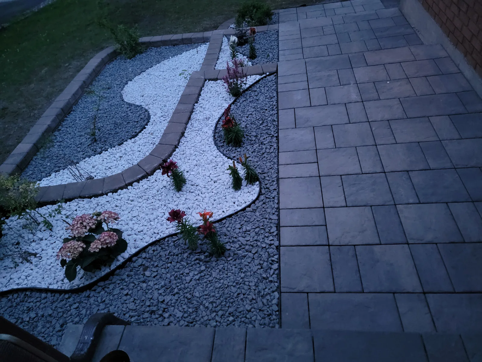 Interlock walkway beside a landscaped stone bed