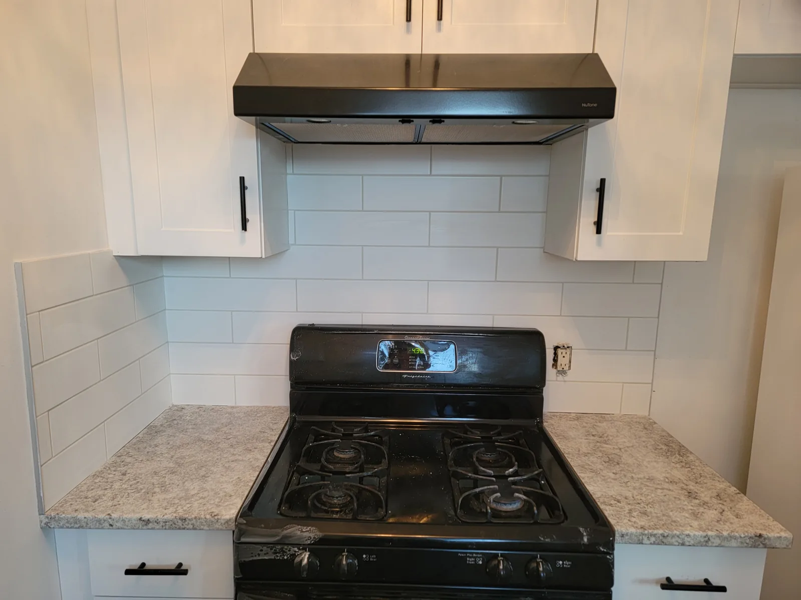 Kitchen stove area with white subway tile backsplash