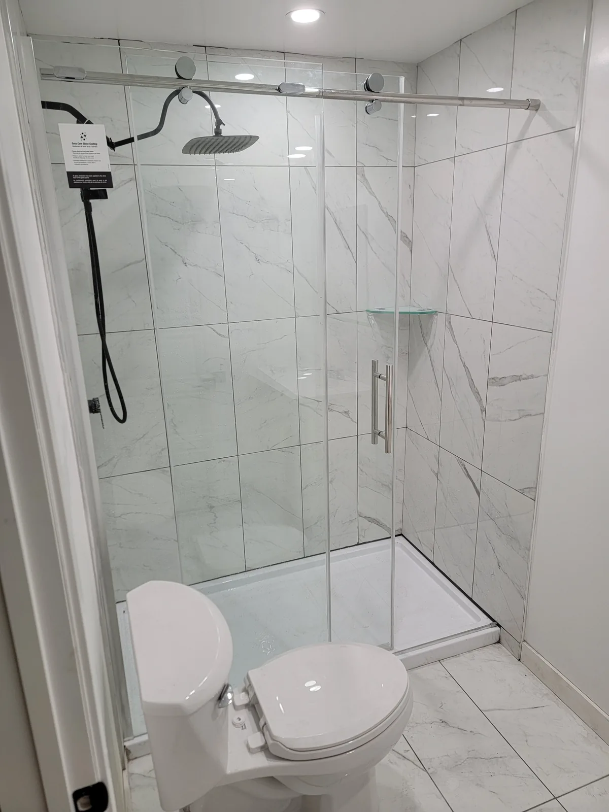 Glass shower with marble-look wall tile
